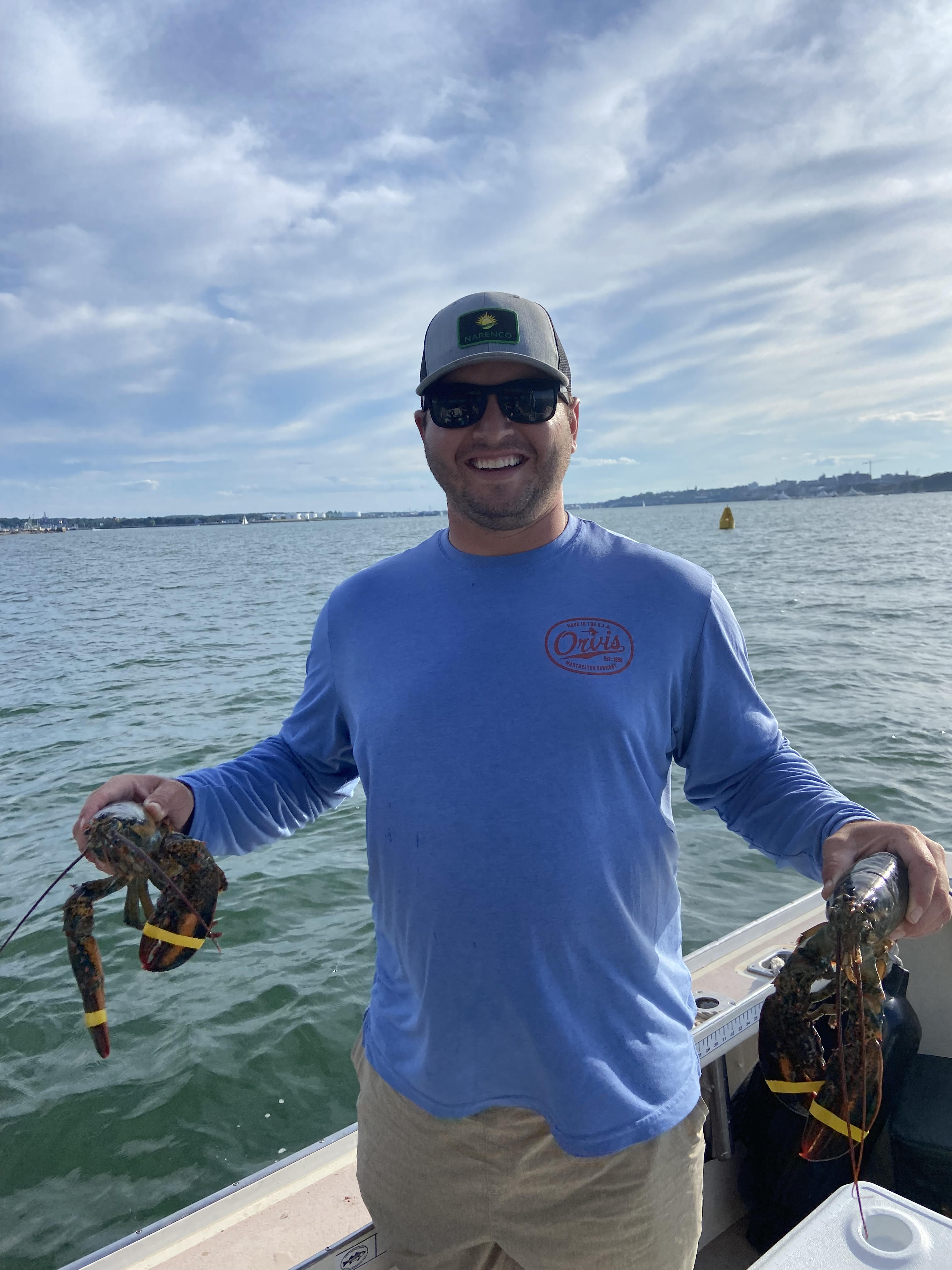 image of Cyle holding a lobster in each hand